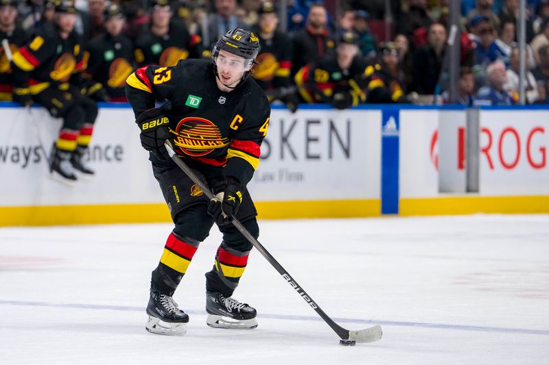 Mar 25, 2024; Vancouver, British Columbia, CAN;  Vancouver Canucks defenseman Quinn Hughes (43) handles the puck against the Los Angeles Kings in the third period at Rogers Arena. Kings won 3 -2. Mandatory Credit: Bob Frid-USA TODAY Sports