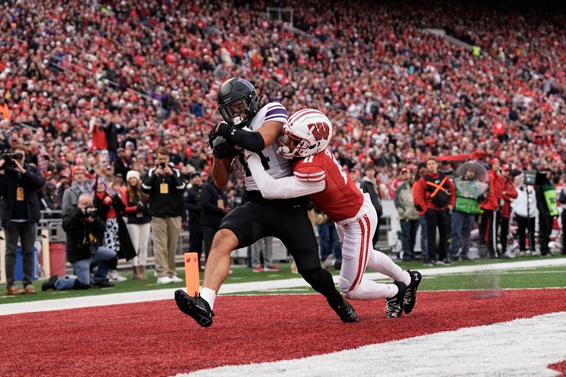 Nov 11, 2023; Madison, Wisconsin, USA;  Northwestern Wildcats wide receiver Cam Johnson (14) catches a pass to score a touchdown in front of Wisconsin Badgers cornerback Alexander Smith (11) during the second quarter at Camp Randall Stadium. Mandatory Credit: Jeff Hanisch-USA TODAY Sports