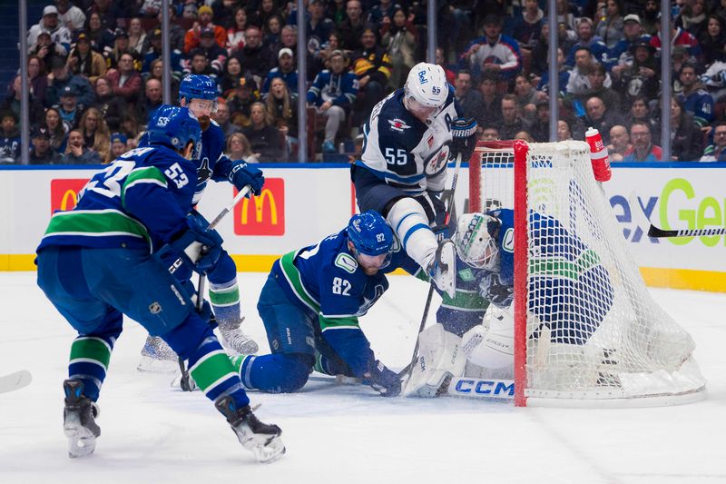 Feb 17, 2024; Vancouver, British Columbia, CAN; Vancouver Canucks defenseman Filip Hronek (17) and defenseman Ian Cole (82) watch as goalie Thatcher Demko (35) makes a save on Winnipeg Jets forward Mark Scheifele (55) in the first period at Rogers Arena. Mandatory Credit: Bob Frid-USA TODAY Sports