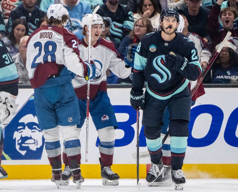 Oct 22, 2024; Seattle, Washington, USA;  Colorado Avalanche forward Joel Kiviranta (94) celebrates scoring a goal with forward Miles Wood (28) during the second period at Climate Pledge Arena. At right is Seattle Kraken defenseman Joshua Mahura (28). Mandatory Credit: Stephen Brashear-Imagn Images