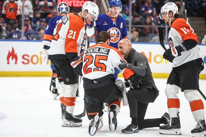 Jan 16, 2025; Elmont, New York, USA;  Philadelphia Flyers center Ryan Poehling (25) is helped off the ice after suffering an injury in the first period against the New York Islanders at UBS Arena. Mandatory Credit: Wendell Cruz-Imagn Images