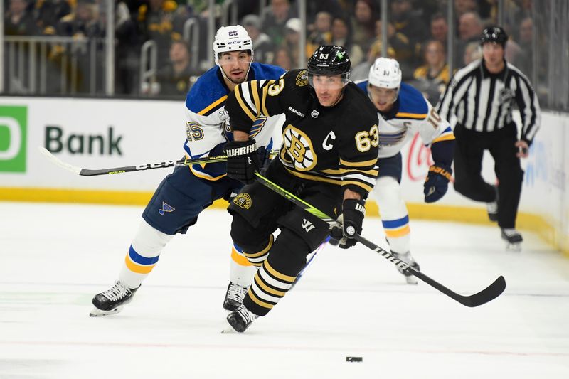 Mar 11, 2024; Boston, Massachusetts, USA;  Boston Bruins left wing Brad Marchand (63) pushes the puck ahead while St. Louis Blues center Jordan Kyrou (25) gives chase during the first period at TD Garden. Mandatory Credit: Bob DeChiara-USA TODAY Sports