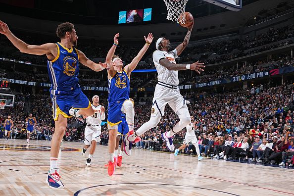 DENVER, CO - DECEMBER 25: Kentavious Caldwell-Pope #5 of the Denver Nuggets drives to the basket during the game against the Golden State Warriors on December 25, 2023 at the Ball Arena in Denver, Colorado. NOTE TO USER: User expressly acknowledges and agrees that, by downloading and/or using this Photograph, user is consenting to the terms and conditions of the Getty Images License Agreement. Mandatory Copyright Notice: Copyright 2023 NBAE (Photo by Garrett Ellwood/NBAE via Getty Images)