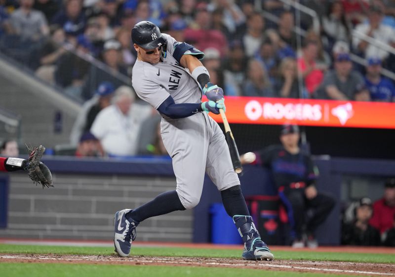 Jun 28, 2024; Toronto, Ontario, CAN; New York Yankees center fielder Aaron Judge (99) hits a single against the Toronto Blue Jays during the sixth inning at Rogers Centre. Mandatory Credit: Nick Turchiaro-USA TODAY Sports