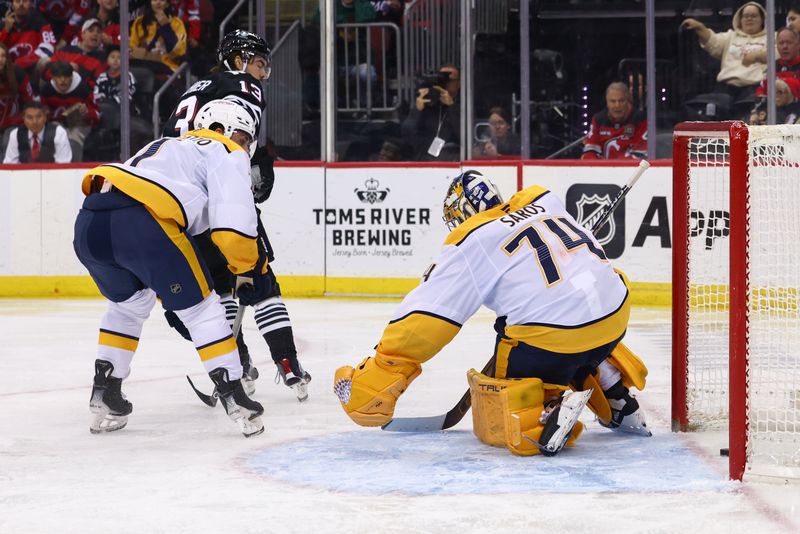 Nov 25, 2024; Newark, New Jersey, USA; New Jersey Devils center Nico Hischier (13) scores a goal on Nashville Predators goaltender Juuse Saros (74) during the second period at Prudential Center. Mandatory Credit: Ed Mulholland-Imagn Images