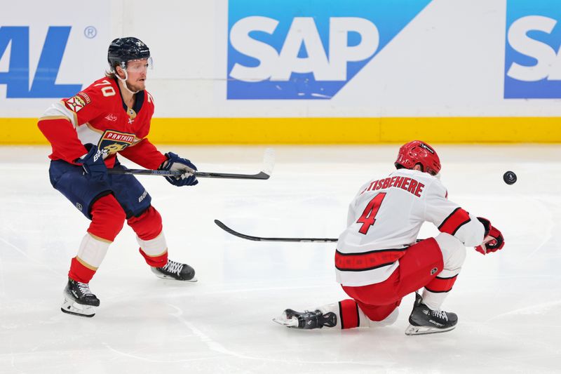 May 24, 2025; Sunrise, Florida, USA; Florida Panthers center Jesper Boqvist (70) and Carolina Hurricanes defenseman Shayne Gostisbehere (4) go for the puck during the second period in game three of the Eastern Conference Final of the 2025 Stanley Cup Playoffs at Amerant Bank Arena. Mandatory Credit: Sam Navarro-Imagn Images