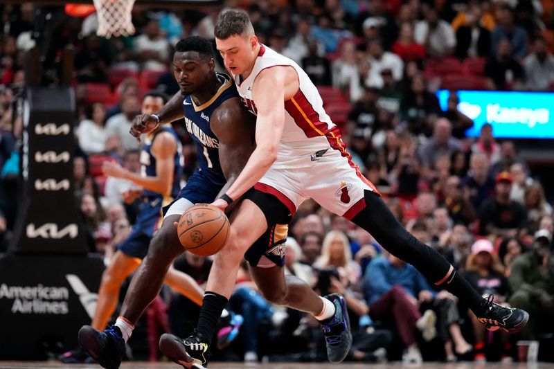 MIAMI, FLORIDA - MARCH 22: Nikola Jovic #5 of the Miami Heat dribbles the ball against Zion Williamson #1 of the New Orleans Pelicans during the third quarter at Kaseya Center on March 22, 2024 in Miami, Florida. NOTE TO USER: User expressly acknowledges and agrees that, by downloading and or using this photograph, User is consenting to the terms and conditions of the Getty Images License Agreement. (Photo by Rich Storry/Getty Images)