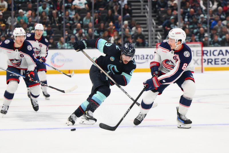 Nov 12, 2024; Seattle, Washington, USA; Columbus Blue Jackets defenseman Zach Werenski (8) passes the puck while defended by Seattle Kraken center Chandler Stephenson (9) during the third period at Climate Pledge Arena. Mandatory Credit: Steven Bisig-Imagn Images