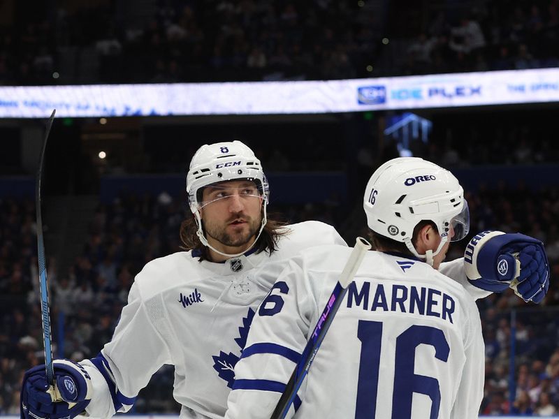 Nov 30, 2024; Tampa, Florida, USA; Toronto Maple Leafs defenseman Chris Tanev (8) is congratulated by right wing Mitch Marner (16) after he scored a goal against the Tampa Bay Lightning during the second period at Amalie Arena. Mandatory Credit: Kim Klement Neitzel-Imagn Images