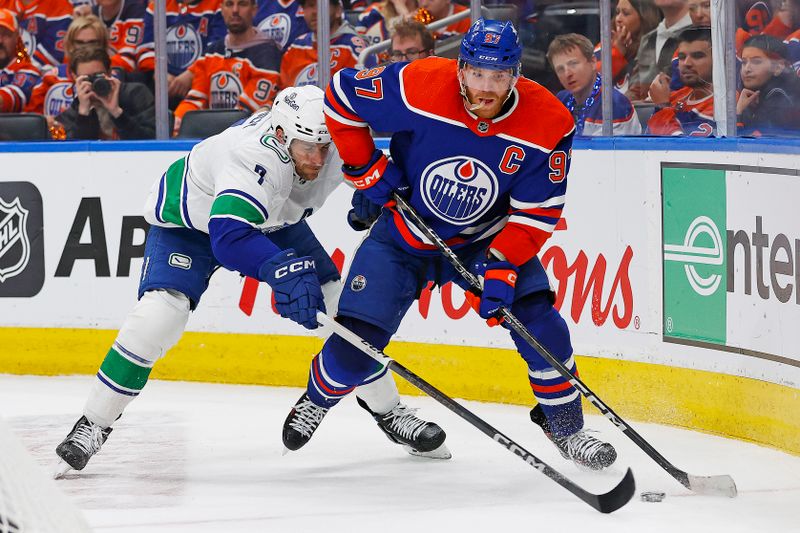 May 12, 2024; Edmonton, Alberta, CAN;Edmonton Oilers forward Connor McDavid (97) protects the puck from Vancouver Canucks defensemen Carson Soucy (7) during the third period in game three of the second round of the 2024 Stanley Cup Playoffs at Rogers Place. Mandatory Credit: Perry Nelson-USA TODAY Sports