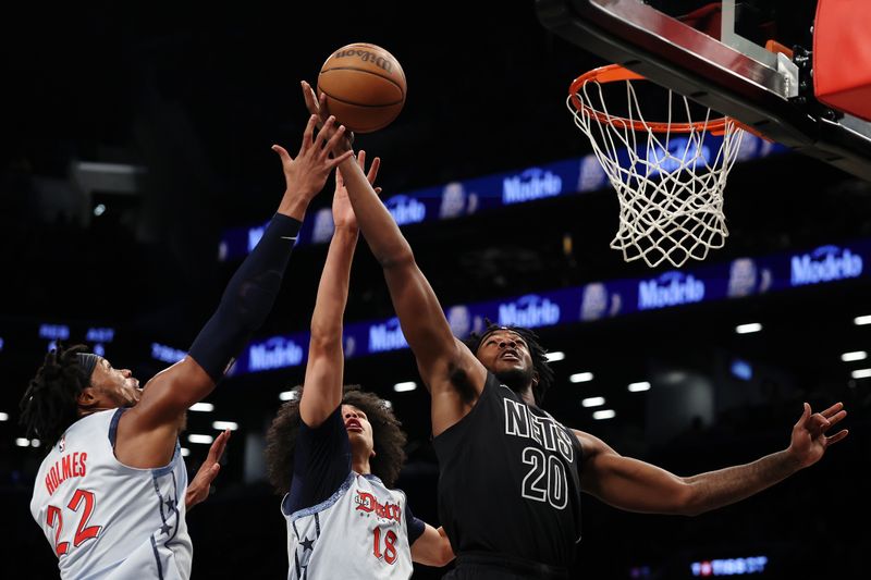 NEW YORK, NEW YORK - FEBRUARY 05: Day'Ron Sharpe #20 of the Brooklyn Nets goes to the basket as Richaun Holmes #22 and Kyshawn George #18 of the Washington Wizards defend during the first half at Barclays Center on February 05, 2025 in the Brooklyn borough of New York City. NOTE TO USER: User expressly acknowledges and agrees that, by downloading and or using this photograph, User is consenting to the terms and conditions of the Getty Images License Agreement. (Photo by Sarah Stier/Getty Images)