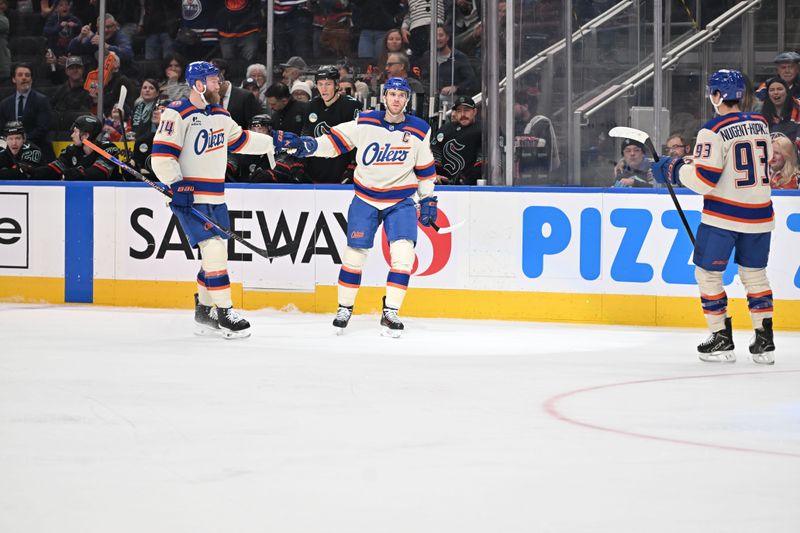 Dec 4, 2025; Edmonton, Alberta, CAN; Edmonton Oilers defenseman Mattias Ekholm (14) and Oilers center Connor McDavid (97) celebrate a goal on Seattle Kraken goalie Joey Daccord (35) during the first period at Rogers Place. Mandatory Credit: Walter Tychnowicz-Imagn Images