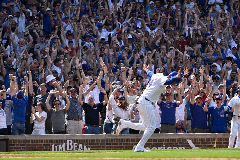 May 18, 2024; Chicago, Illinois, USA; Chicago Cubs outfielder Cody Bellinger (24) celebrates after he slides safely into home plate under Pittsburgh Pirates catcher Joey Bart (14) during the ninth inning  at Wrigley Field. Mandatory Credit: Matt Marton-USA TODAY Sports