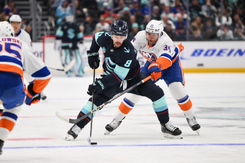 Nov 16, 2024; Seattle, Washington, USA; Seattle Kraken center Chandler Stephenson (9) advances the puck while defended by New York Islanders defenseman Grant Hutton (34) during the third period at Climate Pledge Arena. Mandatory Credit: Steven Bisig-Imagn Images