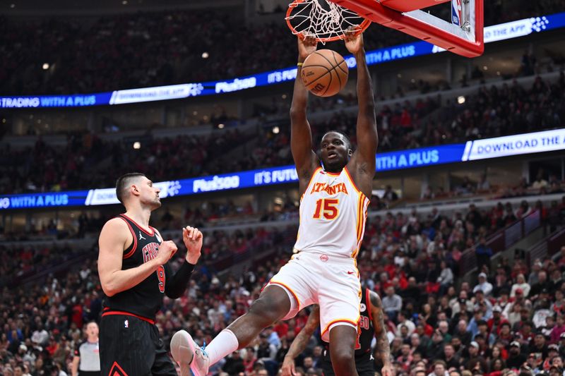 CHICAGO, ILLINOIS - APRIL 17:  Clint Capela #15 of the Atlanta Hawks dunks the ball against Nikola Vucevic #9 of the Chicago Bulls in the first half during the play-in tournament on April 17, 2024 at United Center in Chicago, Illinois. NOTE TO USER: User expressly acknowledges and agrees that, by downloading and or using this photograph, User is consenting to the terms and conditions of the Getty Images License Agreement.  (Photo by Jamie Sabau/Getty Images)