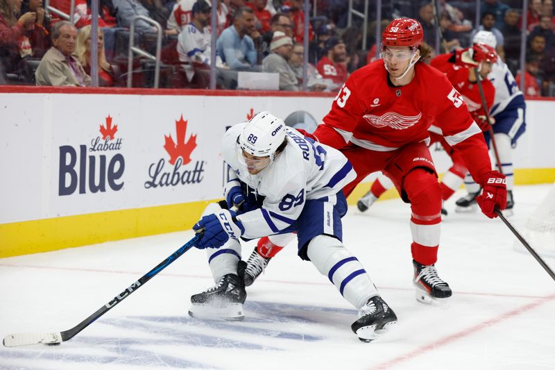 Oct 3, 2024; Detroit, Michigan, USA;  Toronto Maple Leafs left wing Nicholas Robertson (89) skates with the puck defended by Detroit Red Wings defenseman Moritz Seider (53) in the first period at Little Caesars Arena. Mandatory Credit: Rick Osentoski-Imagn Images