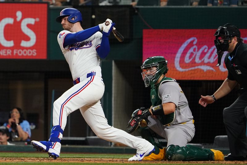 Apr 28, 2025; Arlington, Texas, USA; Texas Rangers catcher Jonah Heim (28) hits an RBI double against the Athletics during the sixth inning at Globe Life Field. Mandatory Credit: Raymond Carlin III-Imagn Images