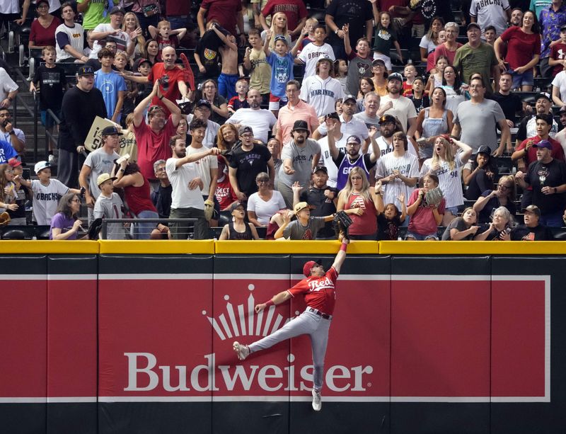 Aug 25, 2023; Phoenix, Arizona, USA; Cincinnati Reds left fielder Spencer Steer (7) is unable to make a catch on a ball hit by Arizona Diamondbacks left fielder Tommy Pham (not pictured) as a fan interferes with the play during the seventh inning at Chase Field. The home run was overturned due to fan interference. Mandatory Credit: Joe Camporeale-USA TODAY Sports