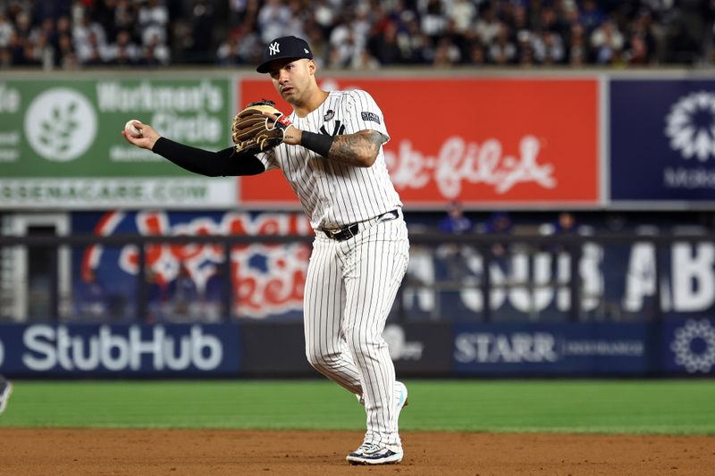 Oct 29, 2024; Bronx, New York, USA; New York Yankees second baseman Gleyber Torres (25) makes a throw to first base against the Los Angeles Dodgers in the sixth inning during game four of the 2024 MLB World Series at Yankee Stadium. Mandatory Credit: Vincent Carchietta-Imagn Images