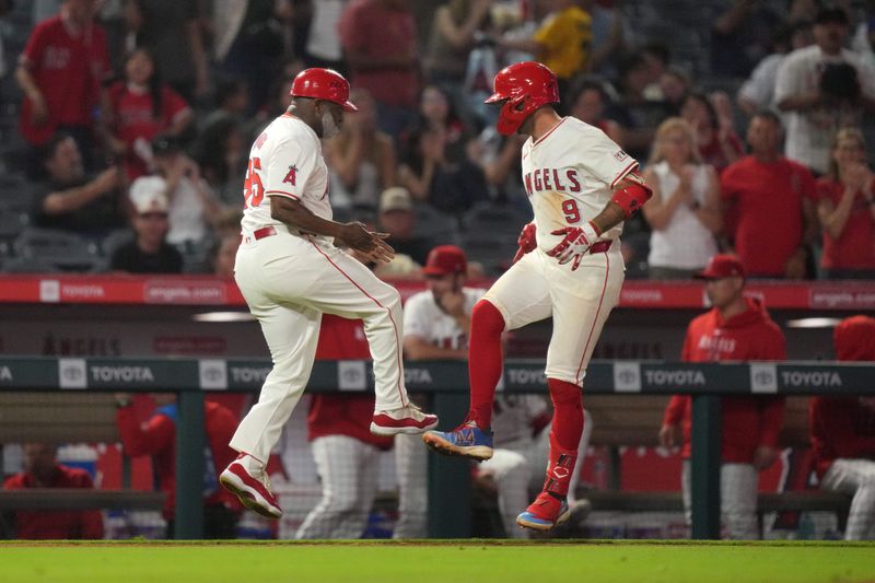 Jul 10, 2024; Anaheim, California, USA; Los Angeles Angels shortstop Zach Neto (9) celebrates with third base coach Eric Young Sr. (85) after hitting a two-run home run in the eighth inning against the Texas Rangers at Angel Stadium. Mandatory Credit: Kirby Lee-USA TODAY Sports
