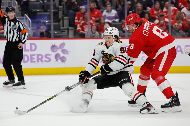 Nov 30, 2023; Detroit, Michigan, USA; Chicago Blackhawks center Connor Bedard (98) skates with the puck defended by Detroit Red Wings defenseman Ben Chiarot (8) in the third period at Little Caesars Arena. Mandatory Credit: Rick Osentoski-USA TODAY Sports