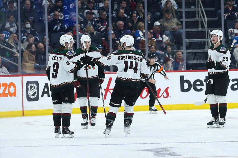 Jan 15, 2023; Winnipeg, Manitoba, CAN; Arizona Coyotes forward Clayton Keller (9) is congratulated by his team mates on his goal against the Winnipeg Jets during the second period at Canada Life Centre. Mandatory Credit: Terrence Lee-USA TODAY Sports