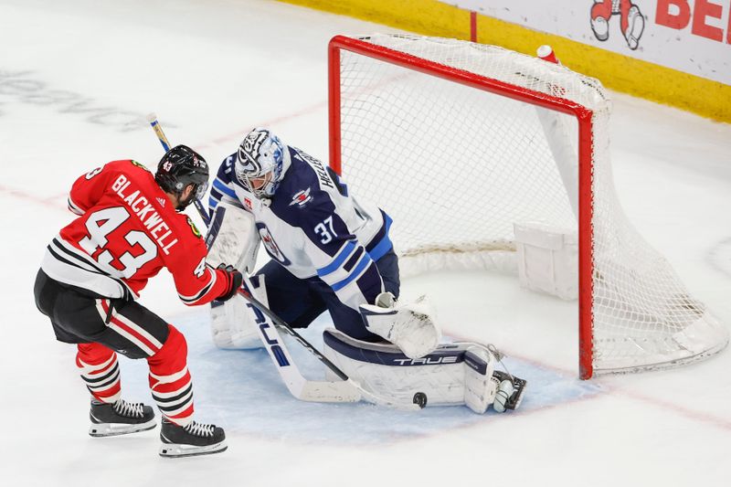 Feb 23, 2024; Chicago, Illinois, USA; Chicago Blackhawks center Colin Blackwell (43) shoots and scores against Winnipeg Jets goaltender Connor Hellebuyck (37) during the second period at United Center. Mandatory Credit: Kamil Krzaczynski-USA TODAY Sports