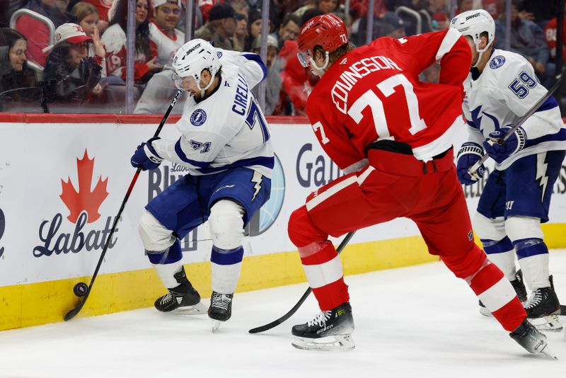 Jan 25, 2025; Detroit, Michigan, USA;  Tampa Bay Lightning center Anthony Cirelli (71) skates with the puck defended by Detroit Red Wings defenseman Simon Edvinsson (77) in the third period at Little Caesars Arena. Mandatory Credit: Rick Osentoski-Imagn Images