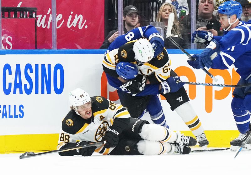 Nov 5, 2024; Toronto, Ontario, CAN; Boston Bruins left wing Brad Marchand (63) battles with Toronto Maple Leafs defenseman Chris Tanev (8) during the first period at Scotiabank Arena. Mandatory Credit: Nick Turchiaro-Imagn Imagess