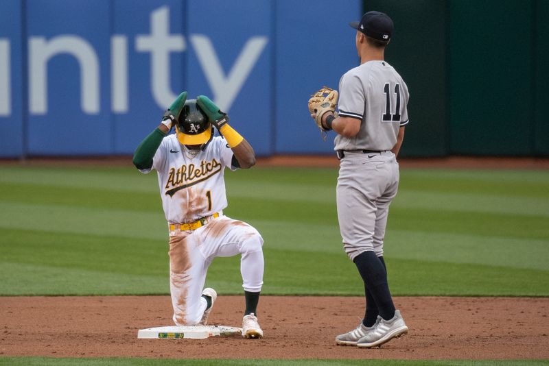 Jun 27, 2023; Oakland, California, USA; Oakland Athletics center fielder Esteury Ruiz (1) grabs his helmet after stealing second base during the third inning against the New York Yankees at Oakland-Alameda County Coliseum. Mandatory Credit: Ed Szczepanski-USA TODAY Sports