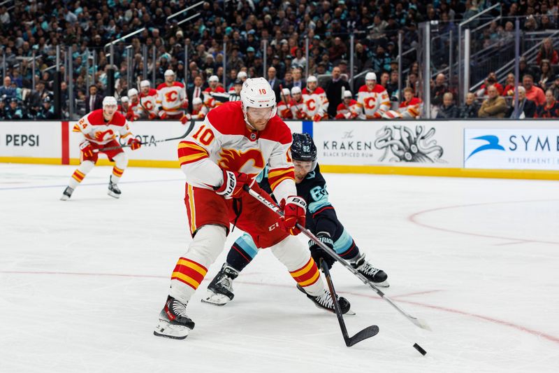 Oct 19, 2024; Seattle, Washington, USA; Calgary Flames center Jonathan Huberdeau (10) shoots as Seattle Kraken defenseman Brandon Montour (62) defends during the second period at Climate Pledge Arena. Mandatory Credit: Caean Couto-Imagn Images