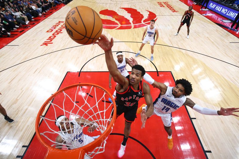 TORONTO, CANADA - MARCH 15:  Ochai Agbaji #30 of the Toronto Raptors  drives to the basket during the game against the Orlando Magic on March 15, 2024 at the Scotiabank Arena in Toronto, Ontario, Canada.  NOTE TO USER: User expressly acknowledges and agrees that, by downloading and or using this Photograph, user is consenting to the terms and conditions of the Getty Images License Agreement.  Mandatory Copyright Notice: Copyright 2024 NBAE (Photo by Vaughn Ridley/NBAE via Getty Images)