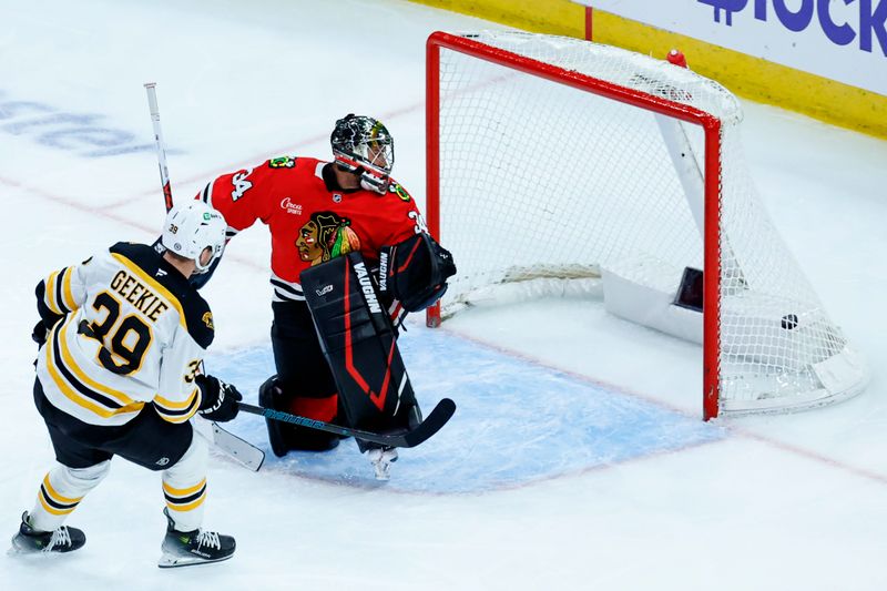 Dec 4, 2024; Chicago, Illinois, USA; Boston Bruins center Morgan Geekie (39) scores against Chicago Blackhawks goalie Petr Mrazek (34) during the third period at United Center. Mandatory Credit: Kamil Krzaczynski-Imagn Images
