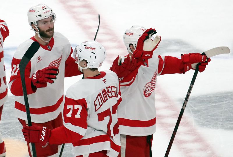 Nov 13, 2024; Pittsburgh, Pennsylvania, USA;  Detroit Red Wings defenseman Simon Edvinsson (77) celebrates with teammates after scoring the game winning goal in overtime against the Pittsburgh Penguins at PPG Paints Arena. Mandatory Credit: Charles LeClaire-Imagn Images