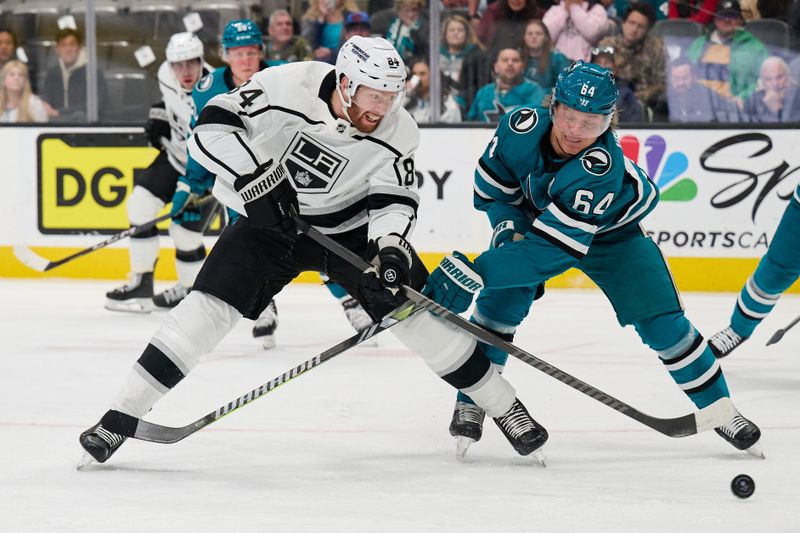 Apr 4, 2024; San Jose, California, USA; Los Angeles Kings defenseman Vladislav Gavrikov (84) shoots the puck against San Jose Sharks center Mikael Granlund (64) during the first period at SAP Center at San Jose. Mandatory Credit: Robert Edwards-USA TODAY Sports