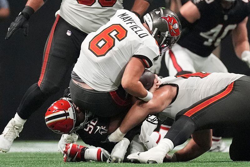 Atlanta Falcons defensive tackle David Onyemata (90) sacks Tampa Bay Buccaneers quarterback Baker Mayfield (6) during the second half of an NFL football game Thursday, Oct. 3, 2024, in Atlanta. (AP Photo/John Bazemore)