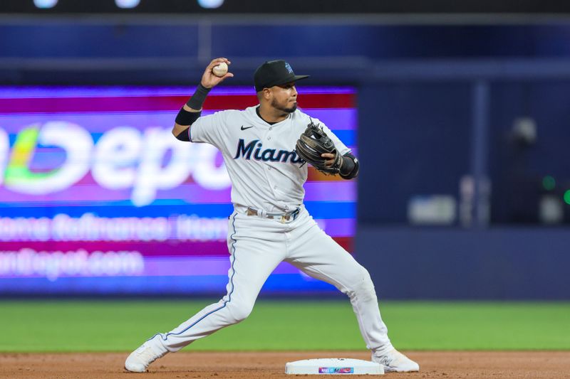 Aug 15, 2023; Miami, Florida, USA; Miami Marlins second baseman Luis Arraez (3) turns a double play against the Houston Astros during the first inning at loanDepot Park. Mandatory Credit: Sam Navarro-USA TODAY Sports