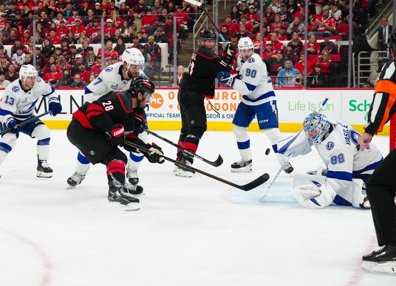 Oct 11, 2024; Raleigh, North Carolina, USA;  Carolina Hurricanes left wing William Carrier (28) shot is stopped by Tampa Bay Lightning goaltender Andrei Vasilevskiy (88) and defenseman Victor Hedman (77) during the third period at PNC Arena. Mandatory Credit: James Guillory-Imagn Images