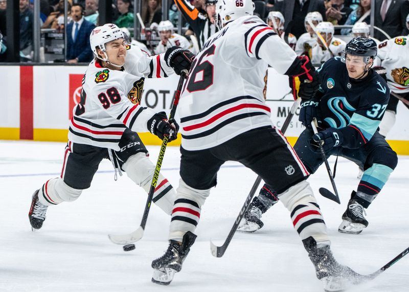 Nov 14, 2024; Seattle, Washington, USA;  Chicago Blackhawks forward Connor Bedard (98) takes a shot against Seattle Kraken forward Yanni Gourde (37) during the second period at Climate Pledge Arena. Mandatory Credit: Stephen Brashear-Imagn Images