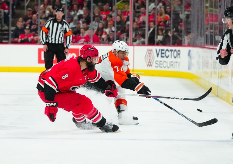 Mar 21, 2024; Raleigh, North Carolina, USA; Carolina Hurricanes defenseman Brent Burns (8) pokes the puck away from Philadelphia Flyers defenseman Erik Johnson (77) during the second period at PNC Arena. Mandatory Credit: James Guillory-USA TODAY Sports