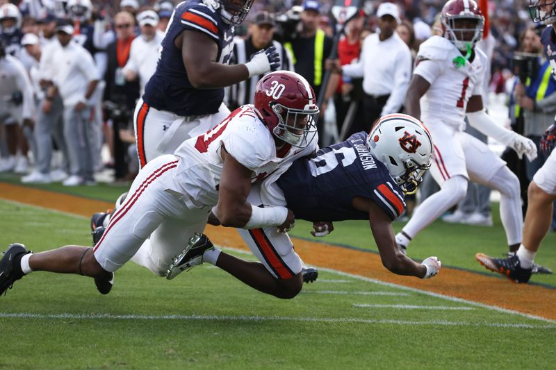 Nov 25, 2023; Auburn, Alabama, USA; Auburn Tigers wide receiver Ja'Varrius Johnson (6) scores a touchdown during the second quarter as Alabama Crimson Tide linebacker Jihaad Campbell (30) defends at Jordan-Hare Stadium. Mandatory Credit: John Reed-USA TODAY Sports