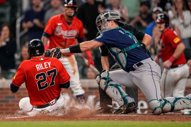 May 19, 2023; Cumberland, Georgia, USA; Seattle Mariners catcher Cal Raleigh (29) is not able to tag out Atlanta Braves third baseman Austin Riley (27) during the eighth inning at Truist Park. Mandatory Credit: Dale Zanine-USA TODAY Sports