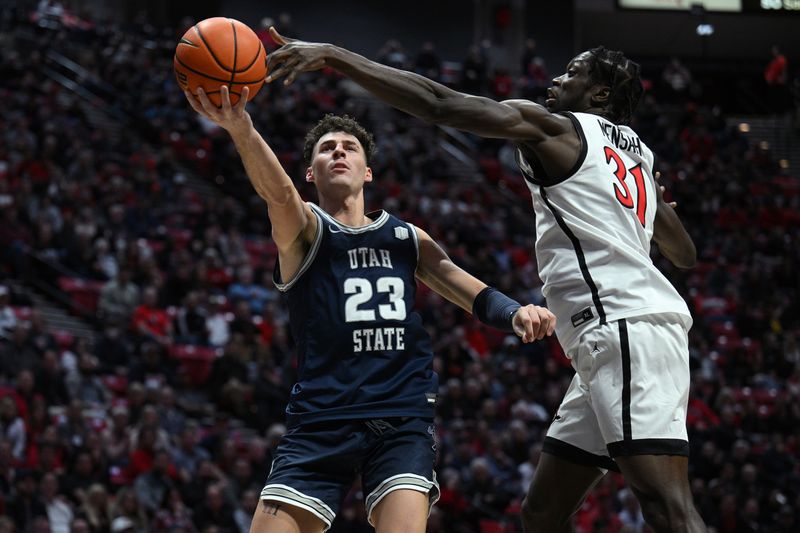 Jan 25, 2023; San Diego, California, USA; Utah State Aggies forward Taylor Funk (23) shoots the ball past San Diego State Aztecs forward Nathan Mensah (31) during the second half at Viejas Arena. Mandatory Credit: Orlando Ramirez-USA TODAY Sports