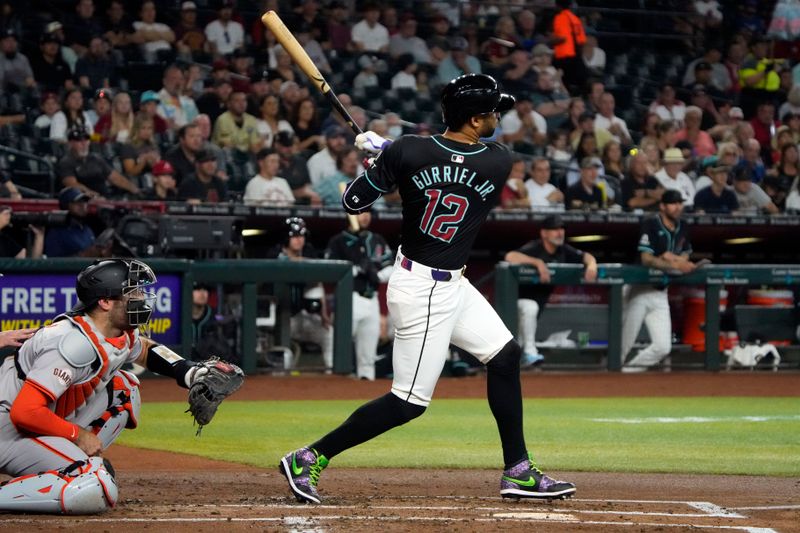 Jun 5, 2024; Phoenix, Arizona, USA; Arizona Diamondbacks outfielder Lourdes Gurriel Jr. (12) hits an RBI single against the San Francisco Giants in the first inning at Chase Field. Mandatory Credit: Rick Scuteri-USA TODAY Sports