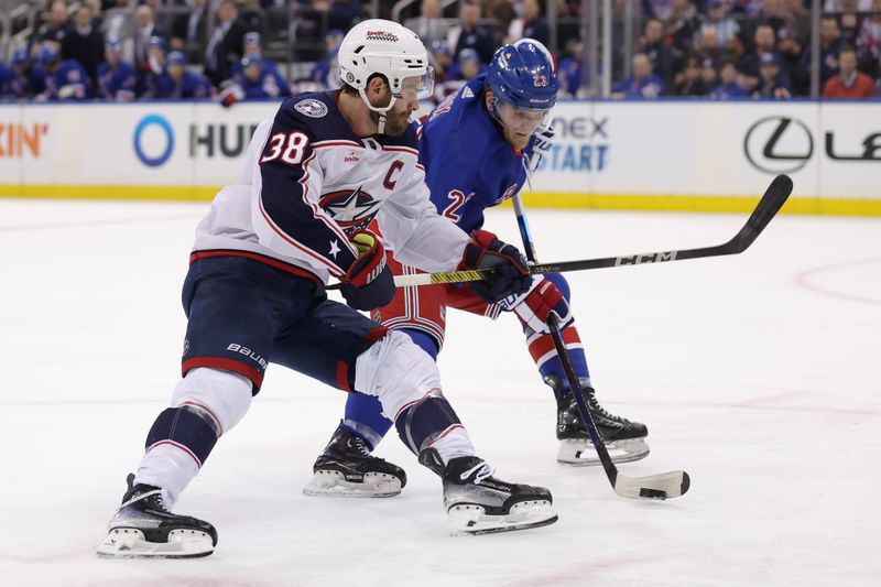 Feb 28, 2024; New York, New York, USA; Columbus Blue Jackets center Boone Jenner (38) and New York Rangers defenseman Adam Fox (23) fight for the puck during the first period at Madison Square Garden. Mandatory Credit: Brad Penner-USA TODAY Sports