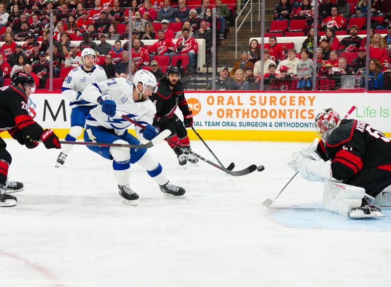 Mar 11, 2025; Raleigh, North Carolina, USA;  Tampa Bay Lightning center Anthony Cirelli (71) gets the shot away against Carolina Hurricanes goaltender Pyotr Kochetkov (52) during the second period at Lenovo Center. Mandatory Credit: James Guillory-Imagn Images