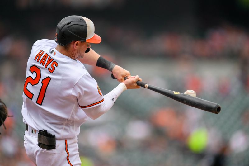 Jun 11, 2023; Baltimore, Maryland, USA; Baltimore Orioles left fielder Austin Hays (21) hits a sacrifice fly during the first inning against the Kansas City Royals at Oriole Park at Camden Yards. Mandatory Credit: Reggie Hildred-USA TODAY Sports