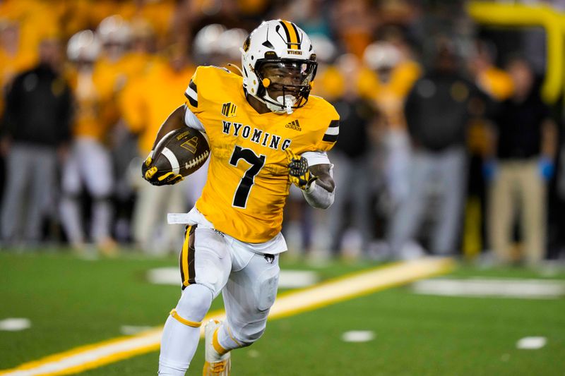 Sep 2, 2023; Laramie, Wyoming, USA; Wyoming Cowboys running back D.Q. James (7) runs against the Texas Tech Red Raiders during the fourth quarter at Jonah Field at War Memorial Stadium. Mandatory Credit: Troy Babbitt-USA TODAY Sports