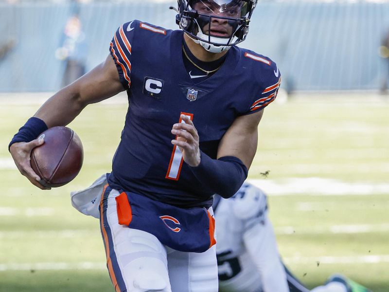 Chicago Bears quarterback Justin Fields (1) rushes with the ball during the first half of an NFL football game against the Philadelphia Eagles, Sunday, Dec. 18, 2022, in Chicago. (AP Photo/Kamil Krzaczynski)