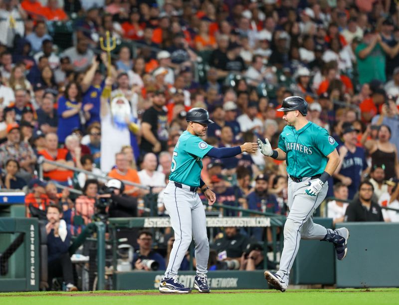 Sep 21, 2025; Houston, Texas, USA; Seattle Mariners third base coach Kristopher Negrón (21) shakes hands with  catcher Cal Raleigh (29) after he hit a two-run home run against the Houston Astros in the second inning at Daikin Park. Mandatory Credit: Thomas Shea-Imagn Images